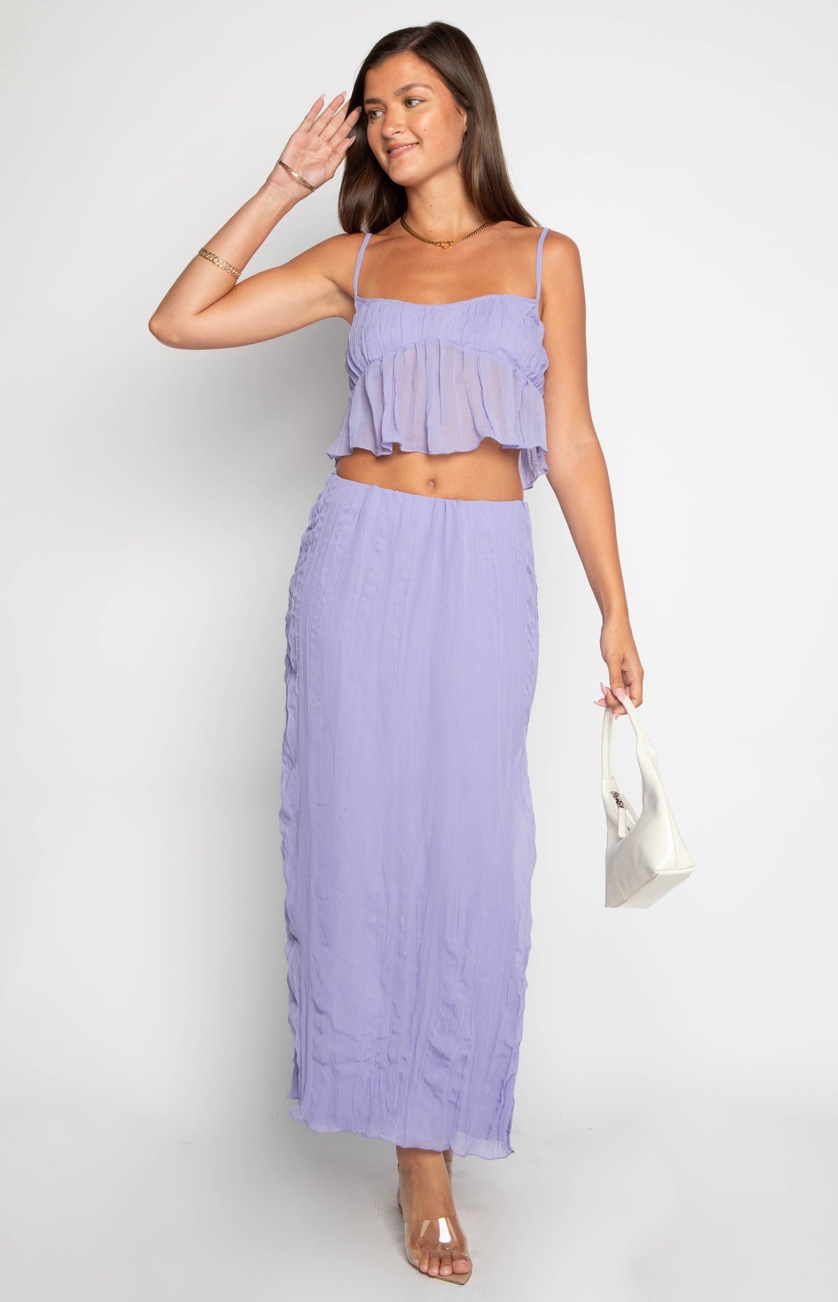 Full length view of a sheer purple crinkled maxi skirt with a fitted waist and vertical ruching down the sides
