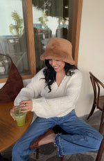 Close-up of a cream chunky knit wrap cardigan with a V-neck and long sleeves, highlighting the textured knit