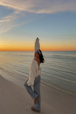 Rear view of a cream knit cardigan with a tie-up back detail and relaxed long sleeves