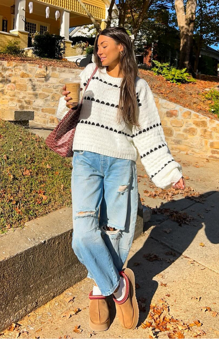 White knit sweater with black heart stripe pattern and relaxed fit