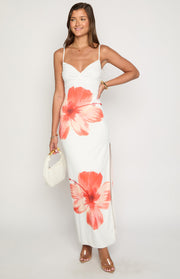 Ruched sweetheart neckline on a white jersey maxi dress with thin spaghetti straps and coral hibiscus print