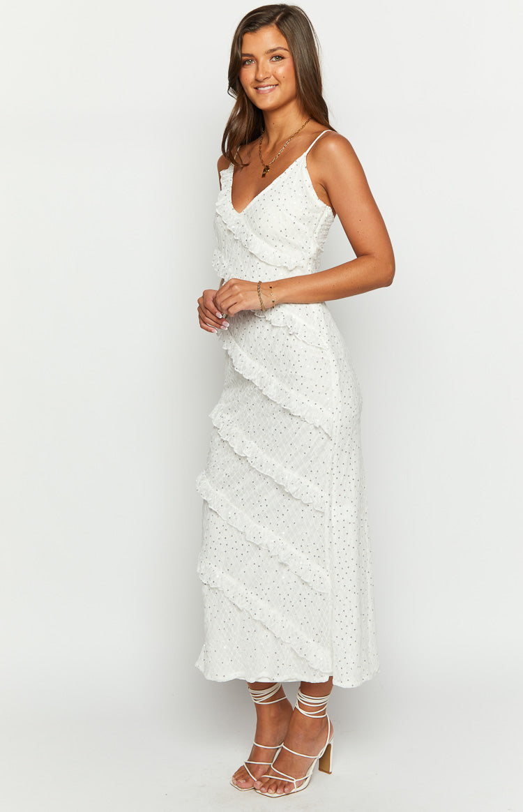 Side view of a white maxi dress with cascading ruffles and a subtle polka dot texture
