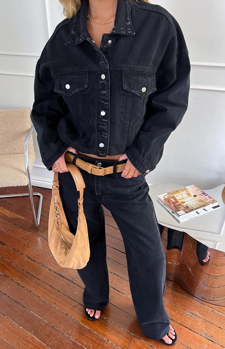 Black oversized denim jacket with distressed collar and placket, silver buttons, and chest pockets