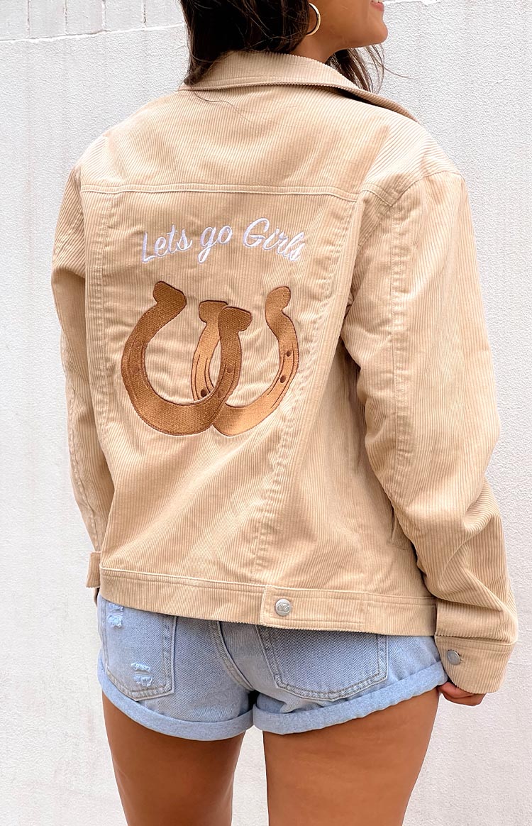 Rear view of a cream corduroy western jacket with 'Lets go Girls' embroidered in white and two brown horseshoes