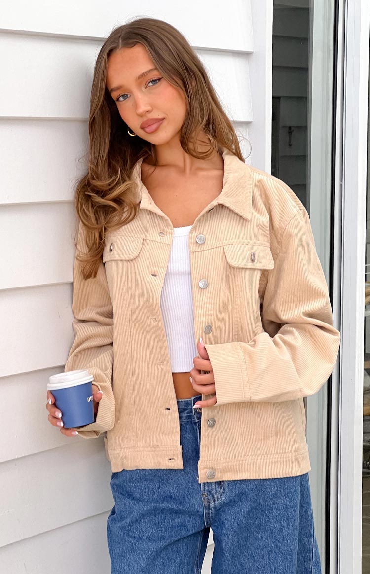 Cream corduroy western jacket with silver buttons, chest pockets, and a relaxed fit, worn open