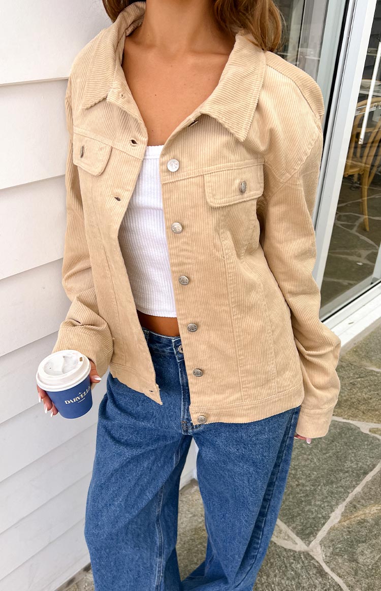 Cream corduroy western jacket with silver buttons down the front, partially unbuttoned, showing chest pockets