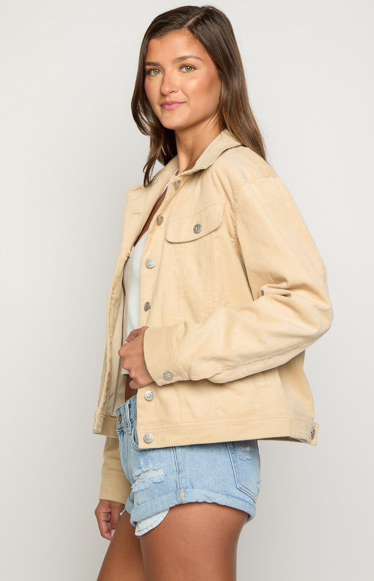 Side view of a cream corduroy western jacket with silver buttons on the front placket, chest pockets, and cuffs