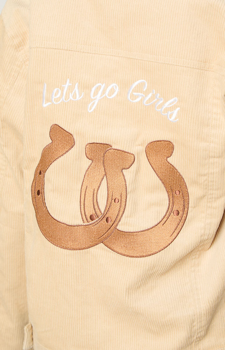 Back detail of a cream corduroy jacket with white 'Lets go Girls' embroidery and brown intertwined horseshoe design