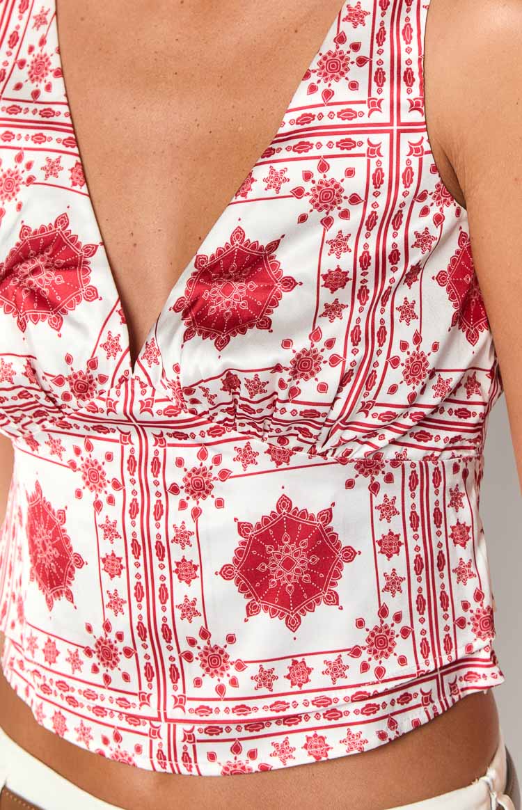 Close-up of the ivory top with red tile print, showing the V-neck and gathered bust detail