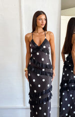 Black polka dot maxi dress with a V-neck, thin spaghetti straps, and tiered sheer ruffles across the bodice and skirt