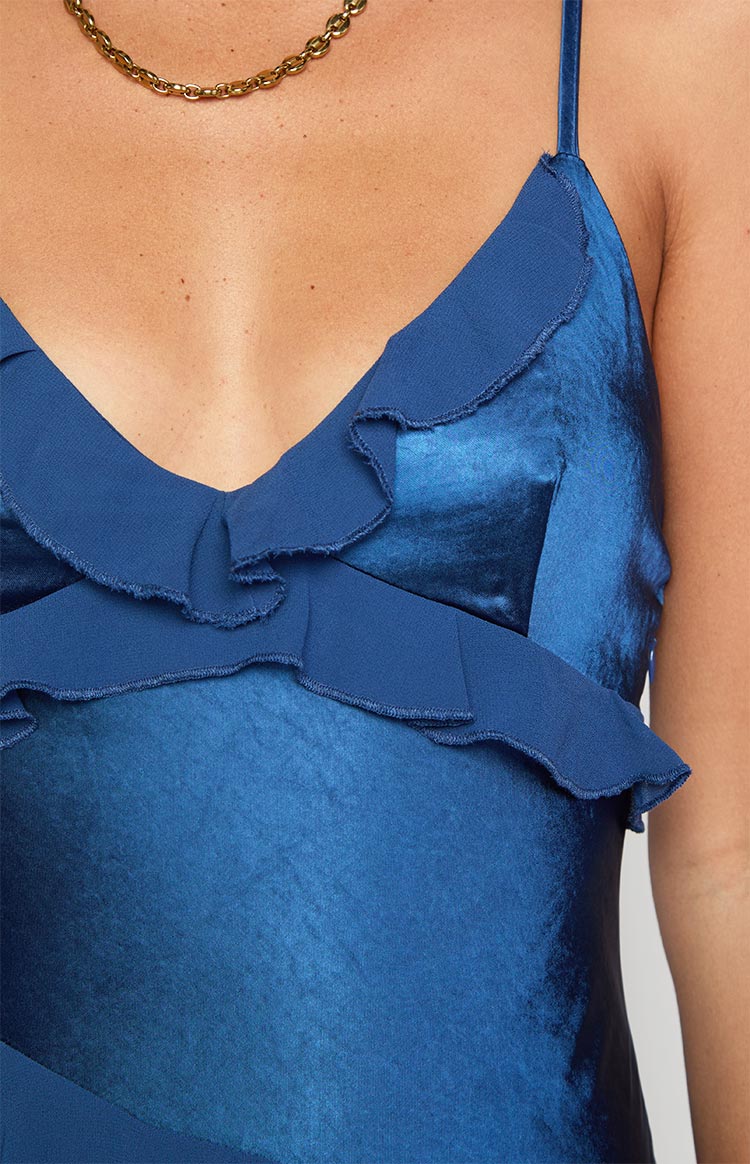 Close-up of the navy V-neckline with raw-edge ruffles and shiny fabric