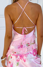 Rear view of a pink floral print maxi dress with criss-cross tie-back straps and tiered ruffles