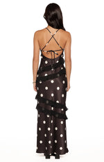 Rear view of a black polka dot maxi dress with criss-cross tie-back spaghetti straps and tiered ruffles