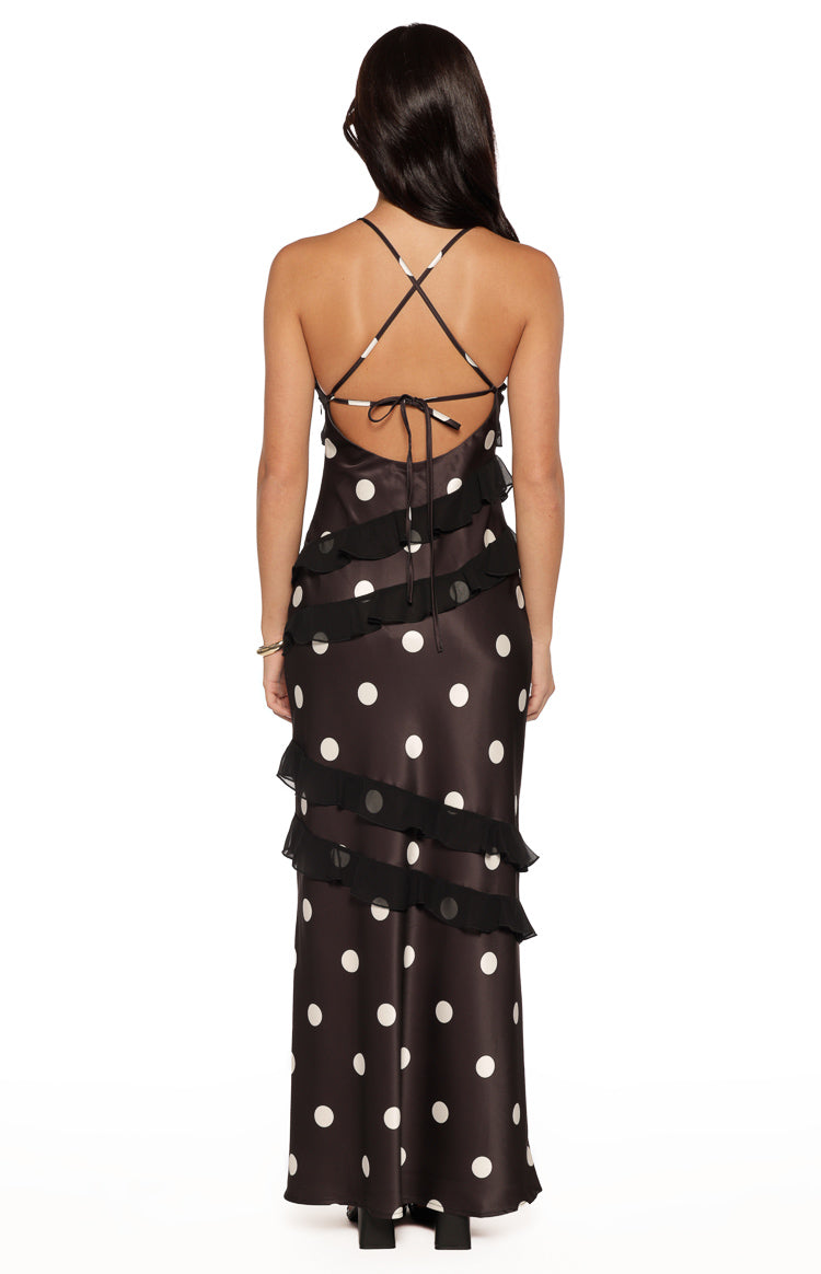 Rear view of a black polka dot maxi dress with criss-cross tie-back spaghetti straps and tiered ruffles