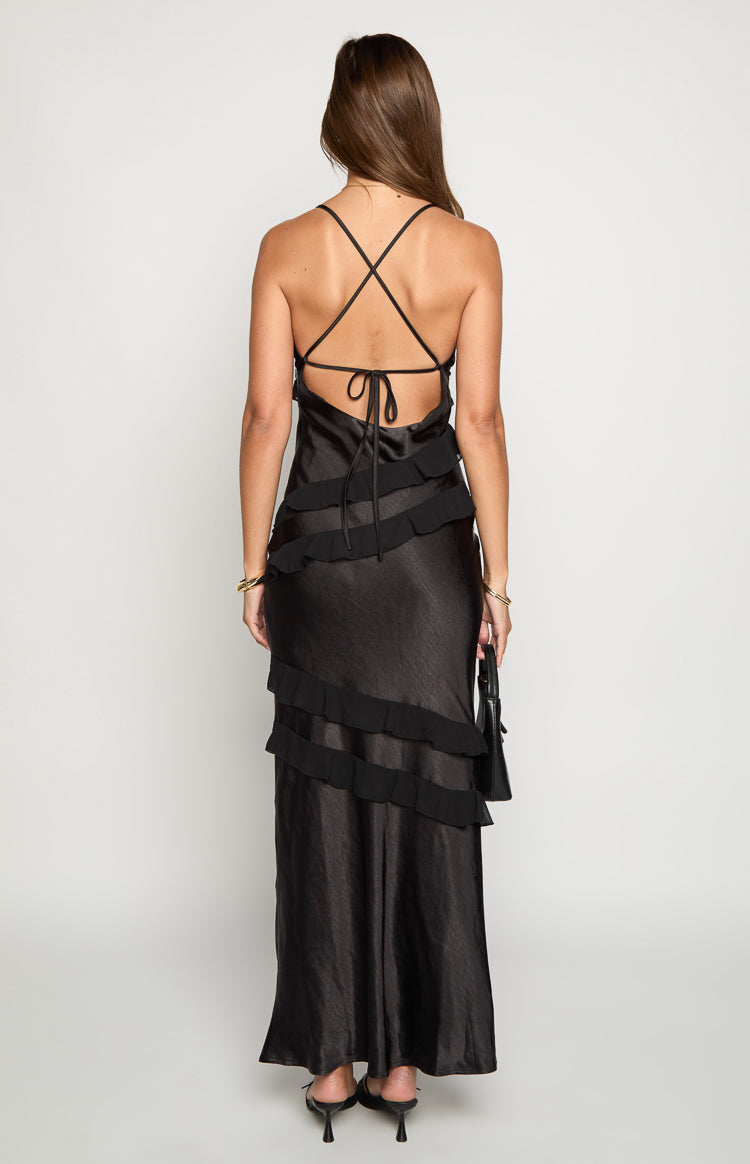 Rear view of a black satin maxi dress with criss-cross back straps, tie detail, and tiered ruffles