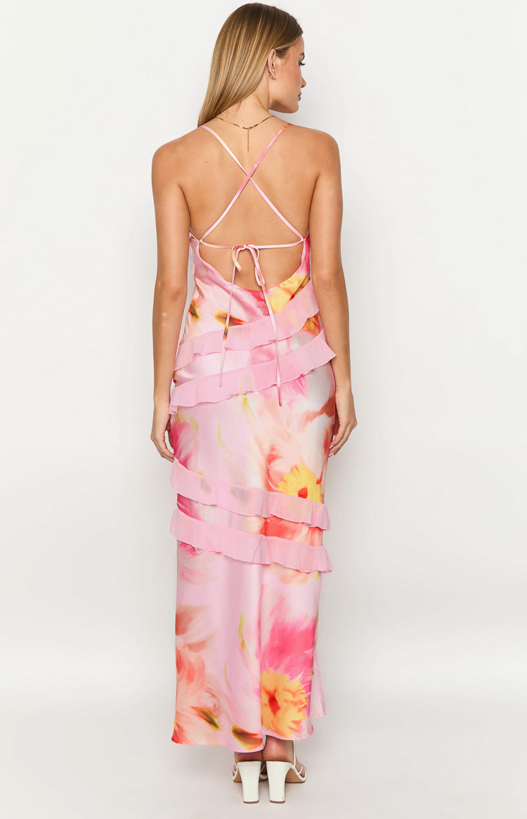 Rear view of a light pink floral print maxi dress with criss-cross tie-back spaghetti straps and horizontal ruffles