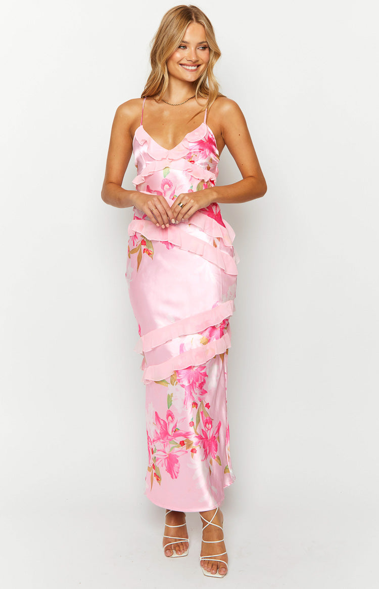 Front view of a pink floral print satin maxi dress with a V-neckline, spaghetti straps, and tiered ruffles