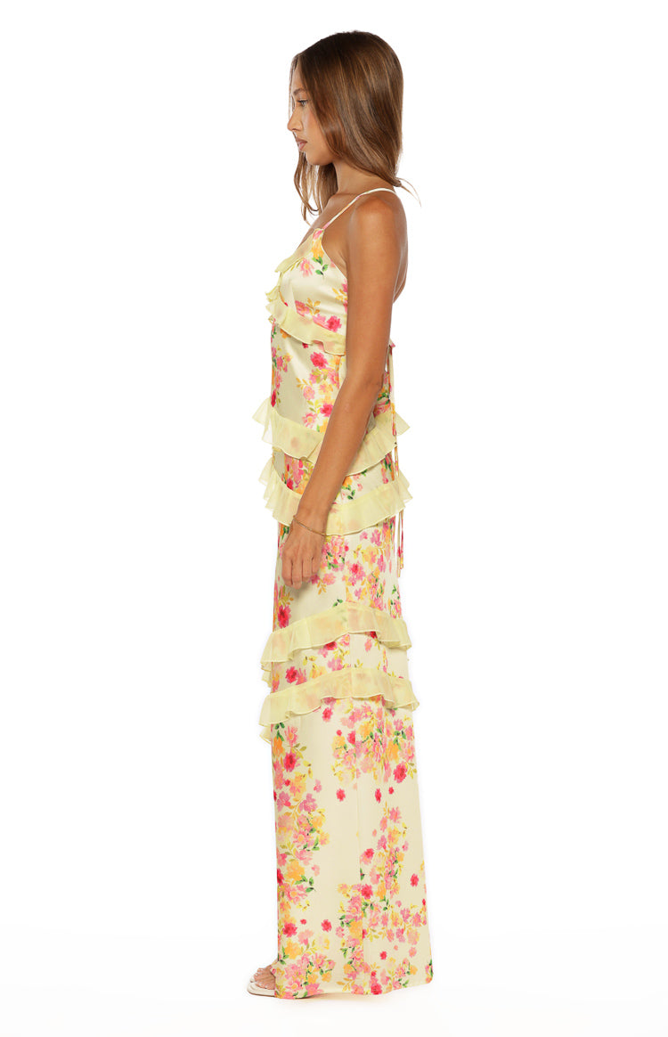 Side view of a yellow floral maxi dress with tiered ruffles and thin spaghetti straps