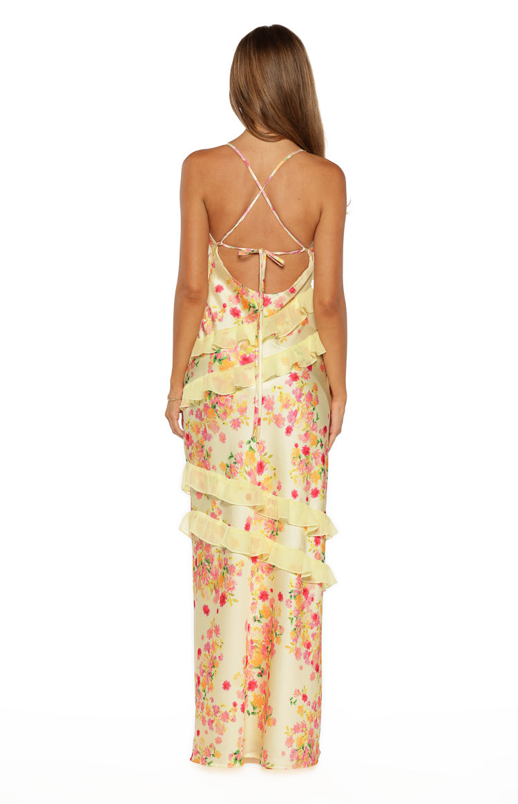 Rear view of a yellow floral maxi dress with criss-cross tie-back straps and tiered yellow ruffles