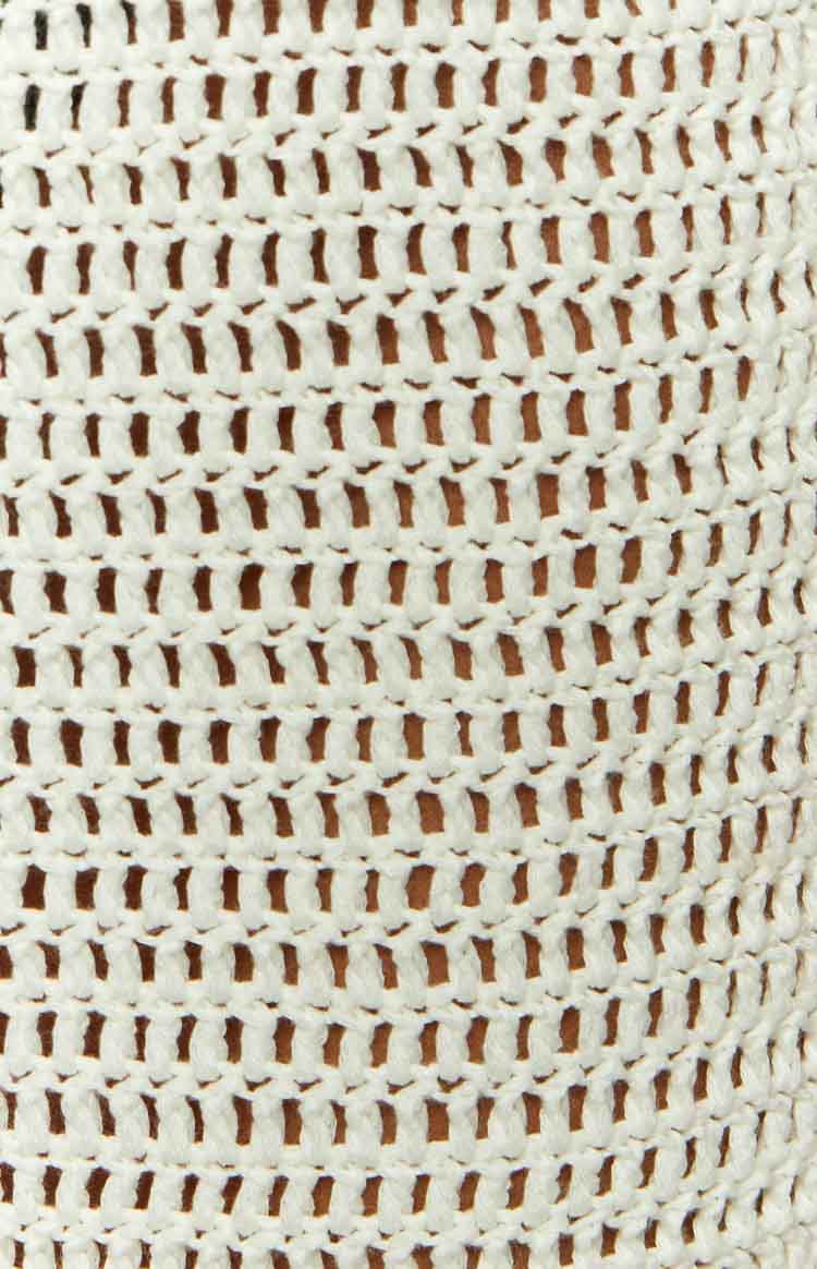 Close-up of the white open-knit crochet fabric of the maxi skirt, showing the intricate texture