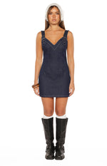 Front view of a dark wash denim mini dress with a V-neckline, buckle detail straps, and white contrast stitching