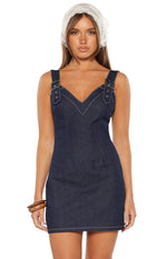 Dark wash denim mini dress with V-neckline, white contrast stitching, and buckle detail on shoulder straps