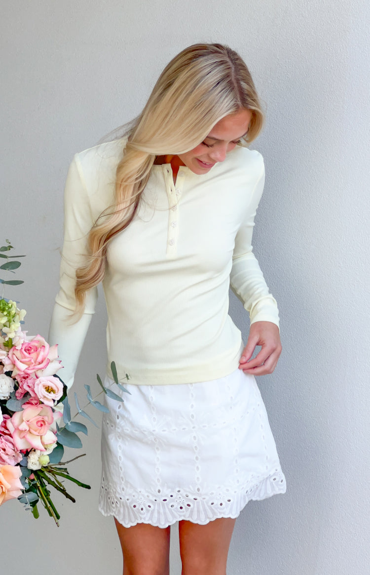 Yellow ribbed long sleeve top with a henley button placket and fitted silhouette