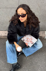 Cropped black faux fur jacket with a wide open collar and fluffy texture