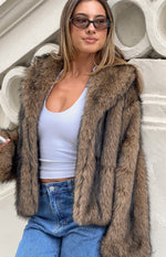 Close-up of the chocolate faux fur jacket showing the textured fur and wide notched lapels