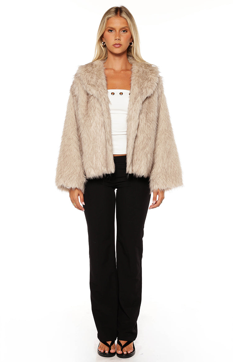 Front view of a sand faux fur jacket with wide lapels and long relaxed sleeves
