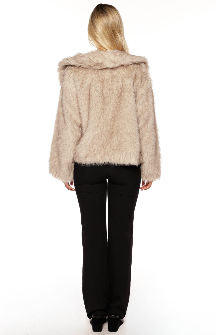 Rear view of a sand faux fur jacket with a wide shawl collar, long sleeves, and a cropped hem