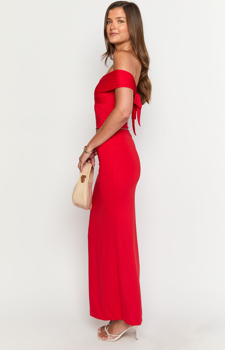 Side view of a red maxi skirt, highlighting its high-waisted, fitted silhouette and floor-length hem