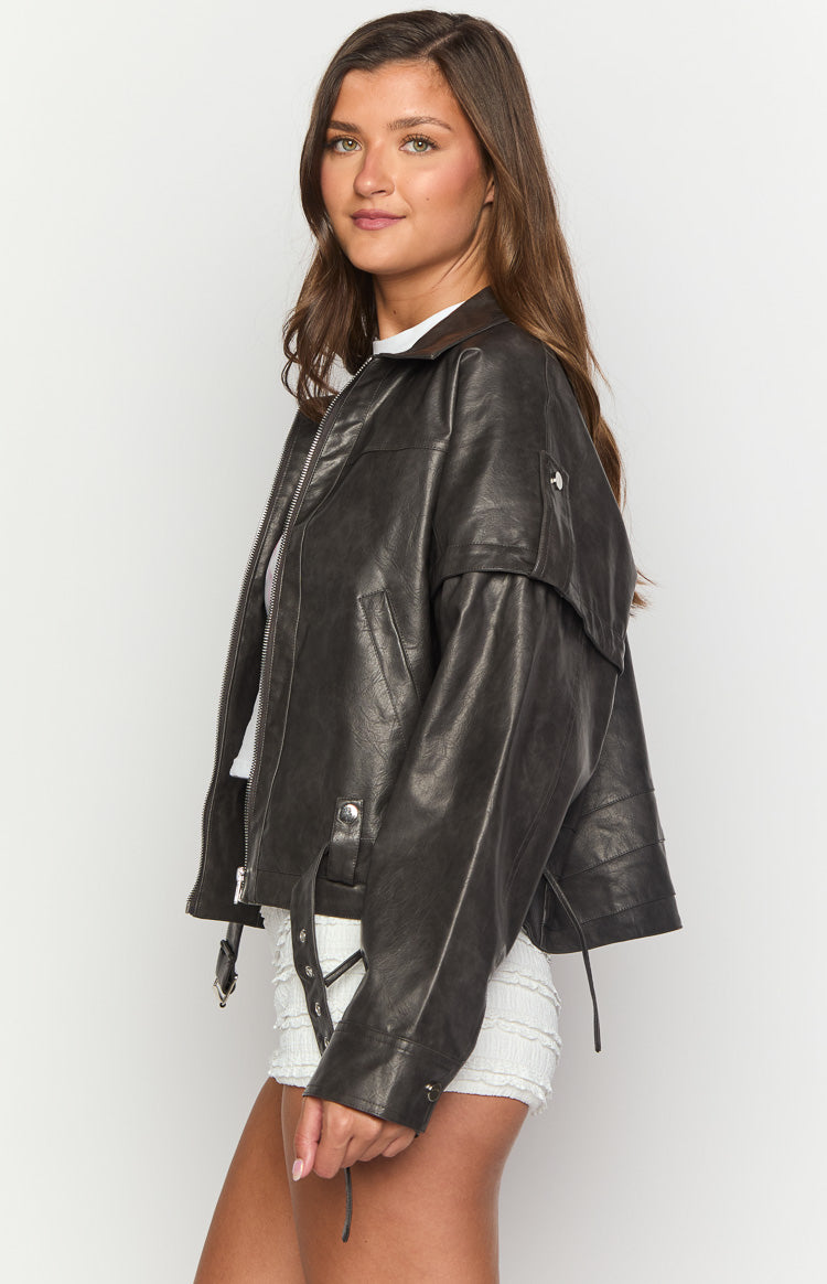 Side profile of a washed black PU jacket with shoulder epaulets and hem buckle detail