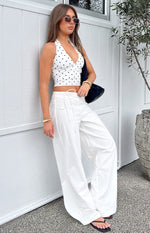 Full length view of white wide-leg pants showing the tie waist detail and a loose, flowing fit