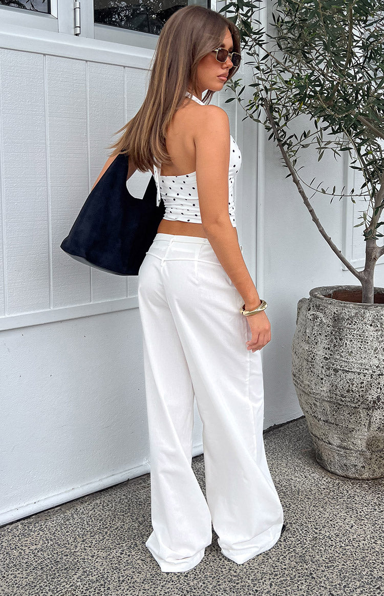 Side-rear view of white wide-leg pants with a V-shaped back waist detail and flowy fabric