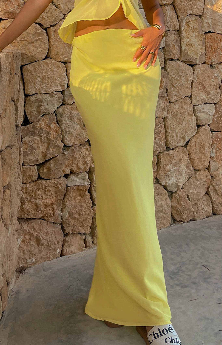 Yellow maxi skirt with a bodycon fit at the waist and hips, flowing down to the floor in a lightweight sheer fabric