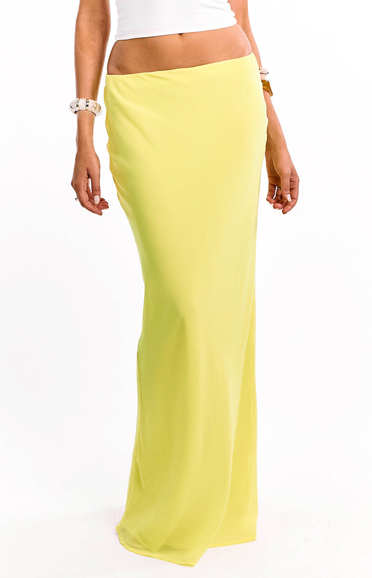 Close-up of the high-waisted yellow maxi skirt showing the smooth fabric and flowing drape
