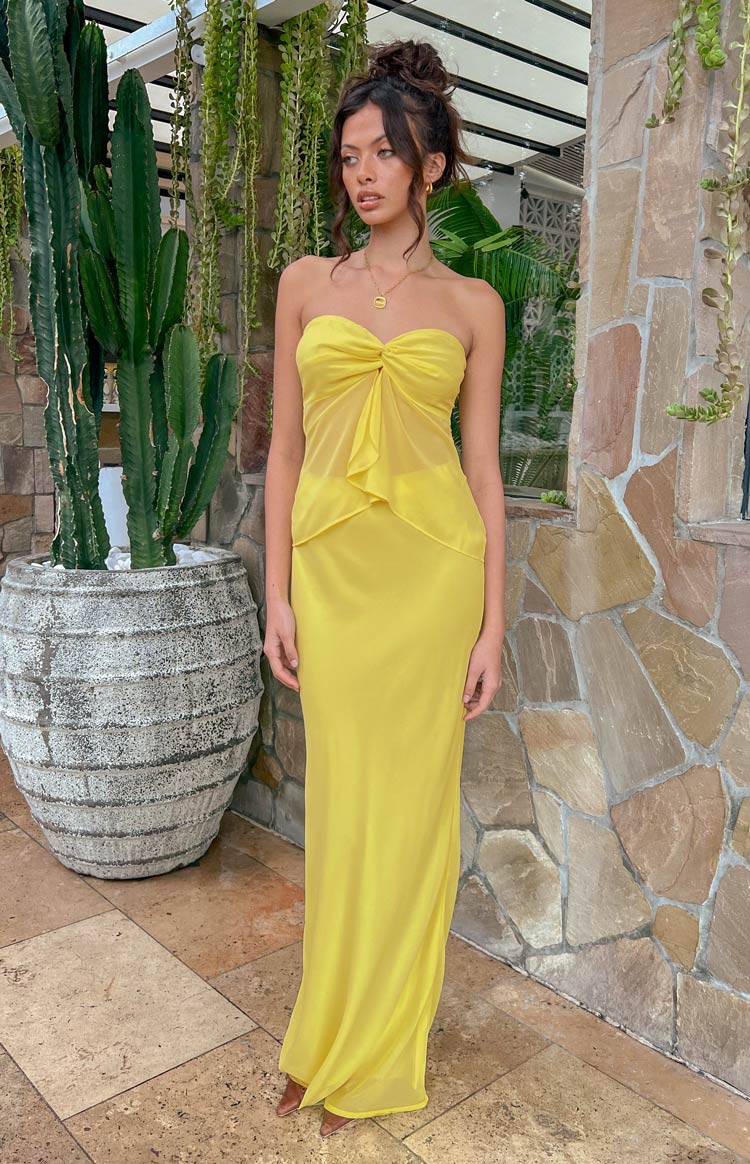 Front view of a sheer yellow maxi skirt with a fitted high waist and flowing floor-length hem