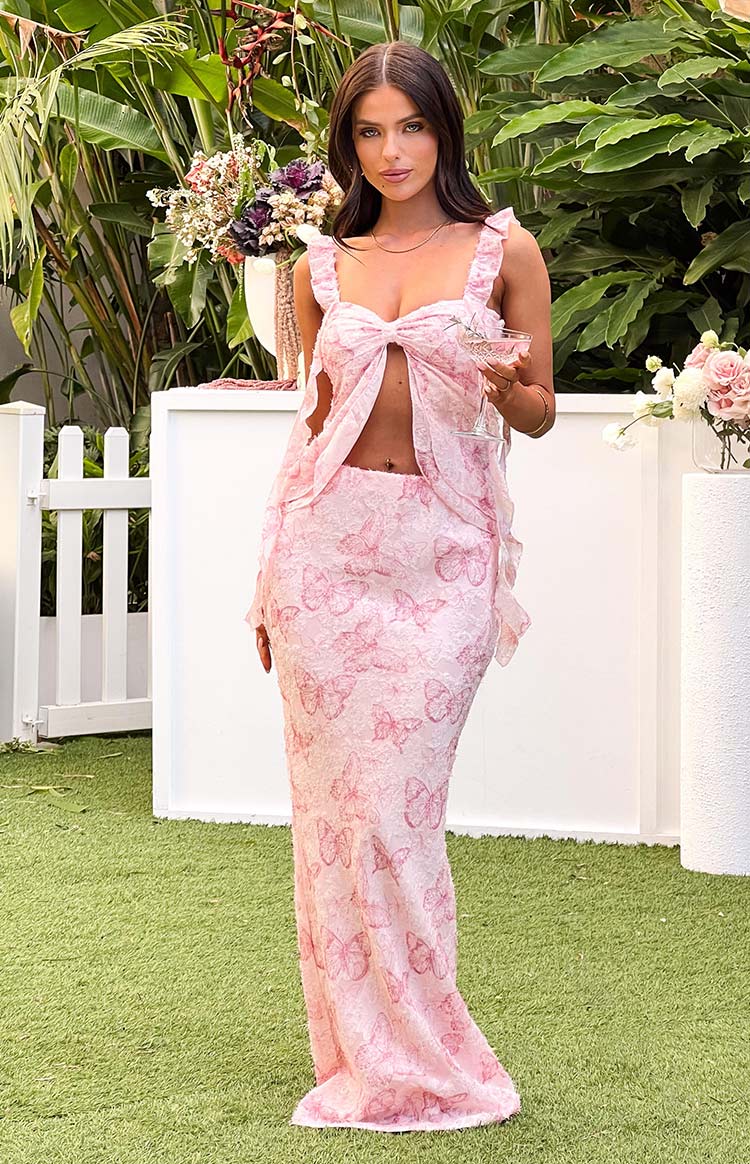 Full length view of the fitted pink maxi skirt with all-over embroidered butterfly pattern
