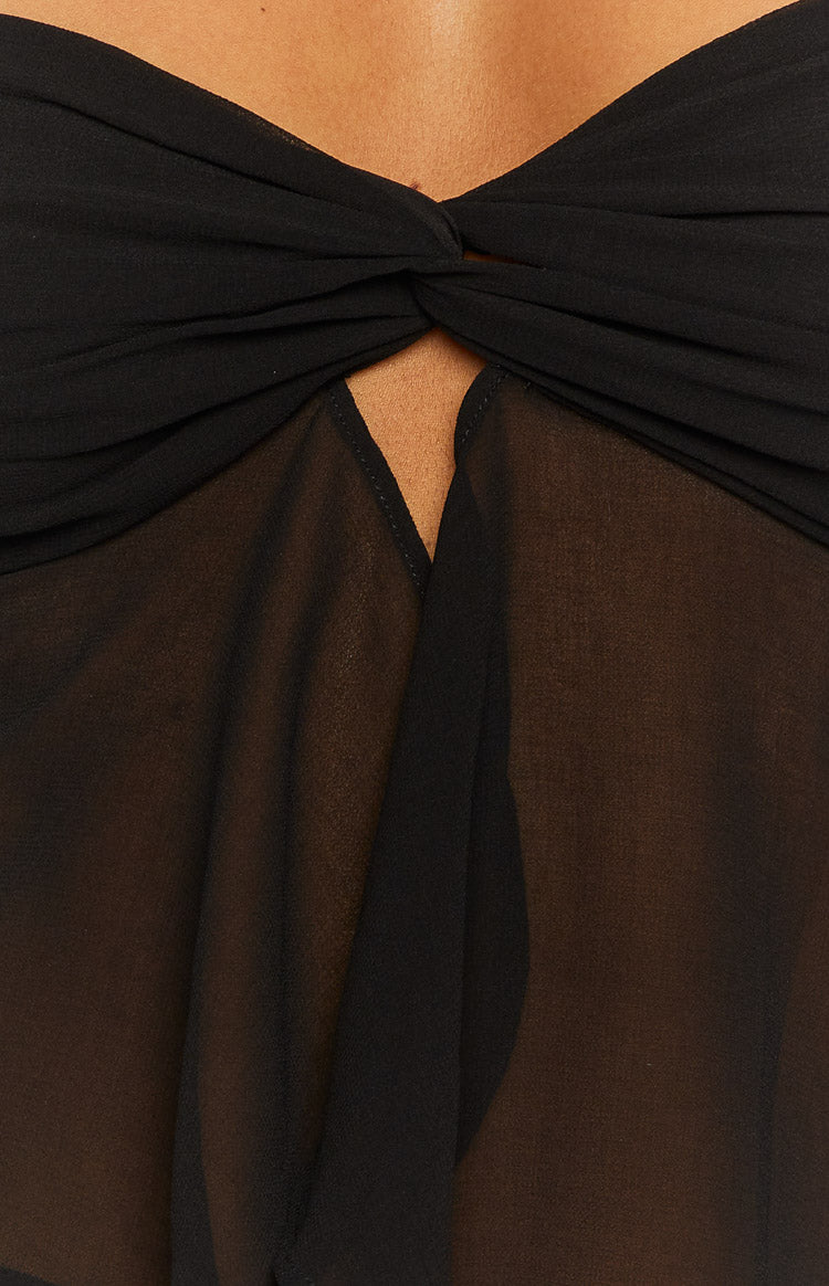 Close-up of the twisted bust detail on a black strapless top with a sheer V-neck bodice