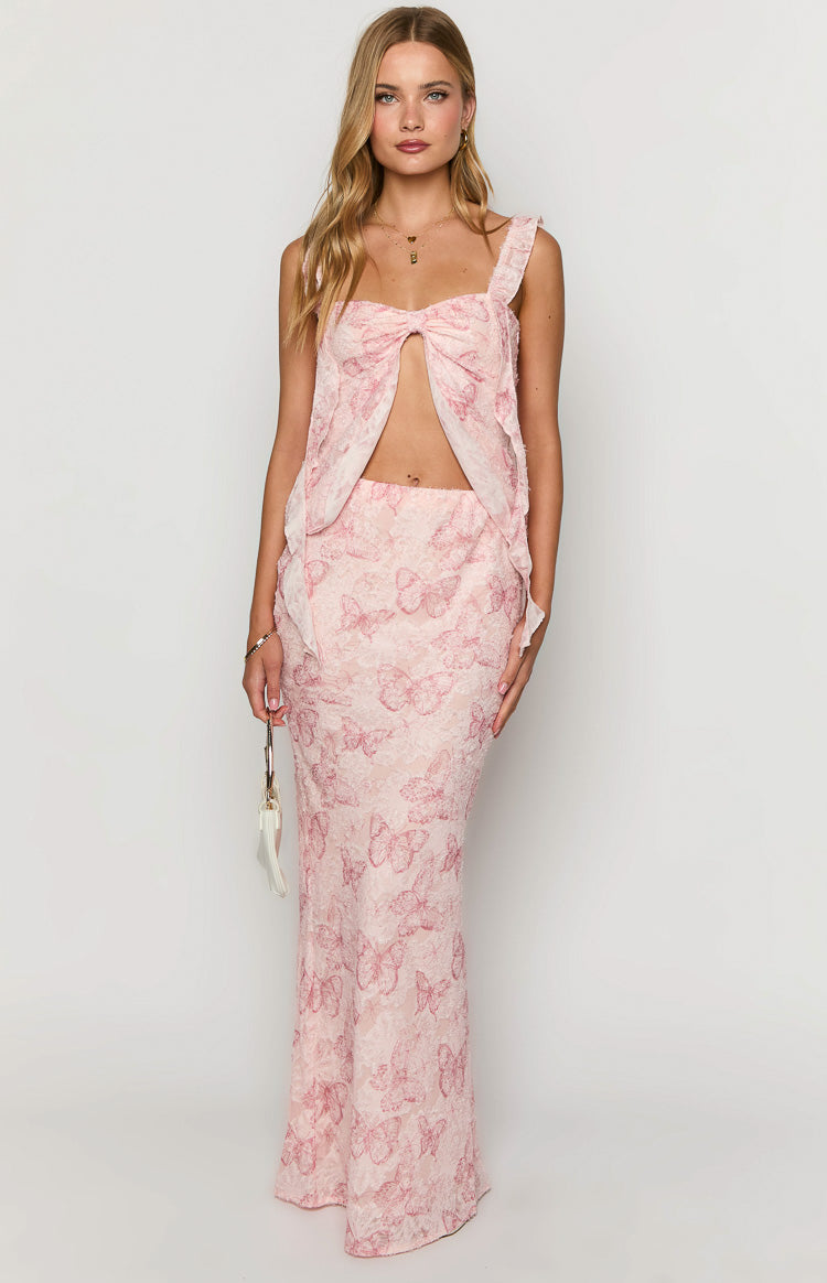 Full length view of a light pink maxi skirt featuring an intricate red butterfly lace pattern and a straight fit