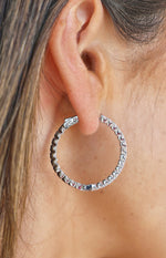 Close-up of the silver diamante hoop earring showing the individual stone settings and the top clasp