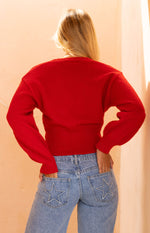 Rear view of a red knit oversized cardigan with ribbed hem and balloon sleeves