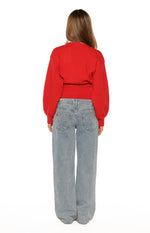 Rear view of the red oversized knit cardigan with long sleeves and a ribbed hem