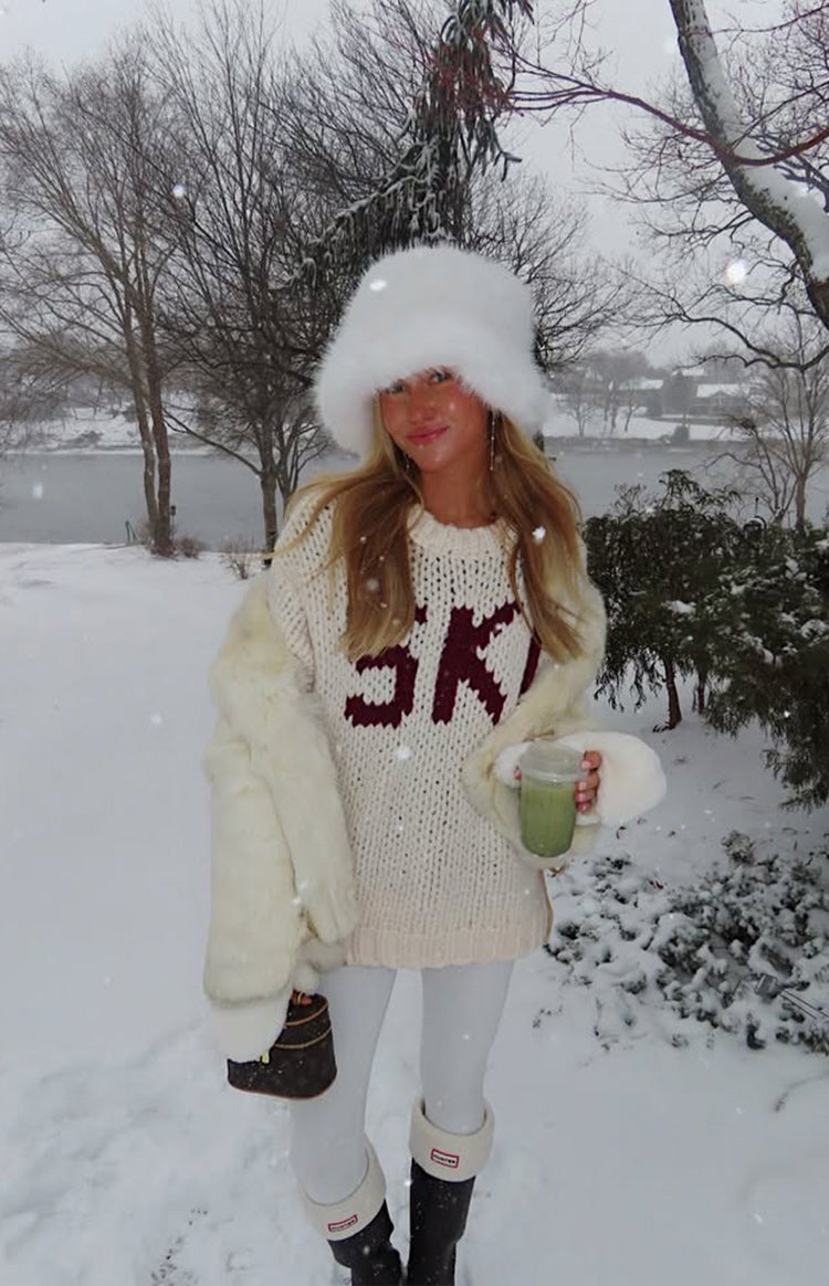 Front view of a cream chunky knit sweater with bold red jacquard SKI lettering and a relaxed fit