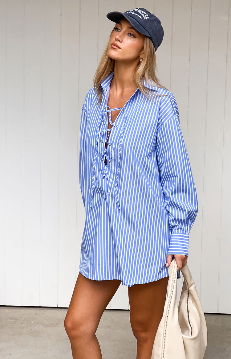 Relaxed fit blue pinstripe mini shirt dress with a collared lace-up V-neck and long sleeves