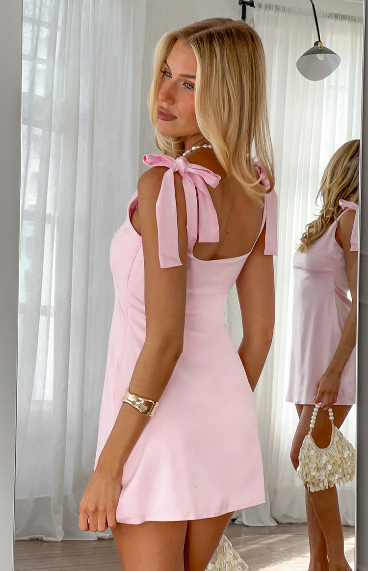 Rear view of a baby pink mini dress showing the wide tie-shoulder straps and square back