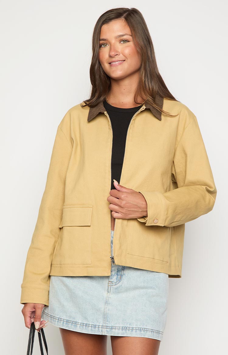Cream canvas jacket with a brown contrast collar, relaxed fit, full zip front, and two square patch pockets