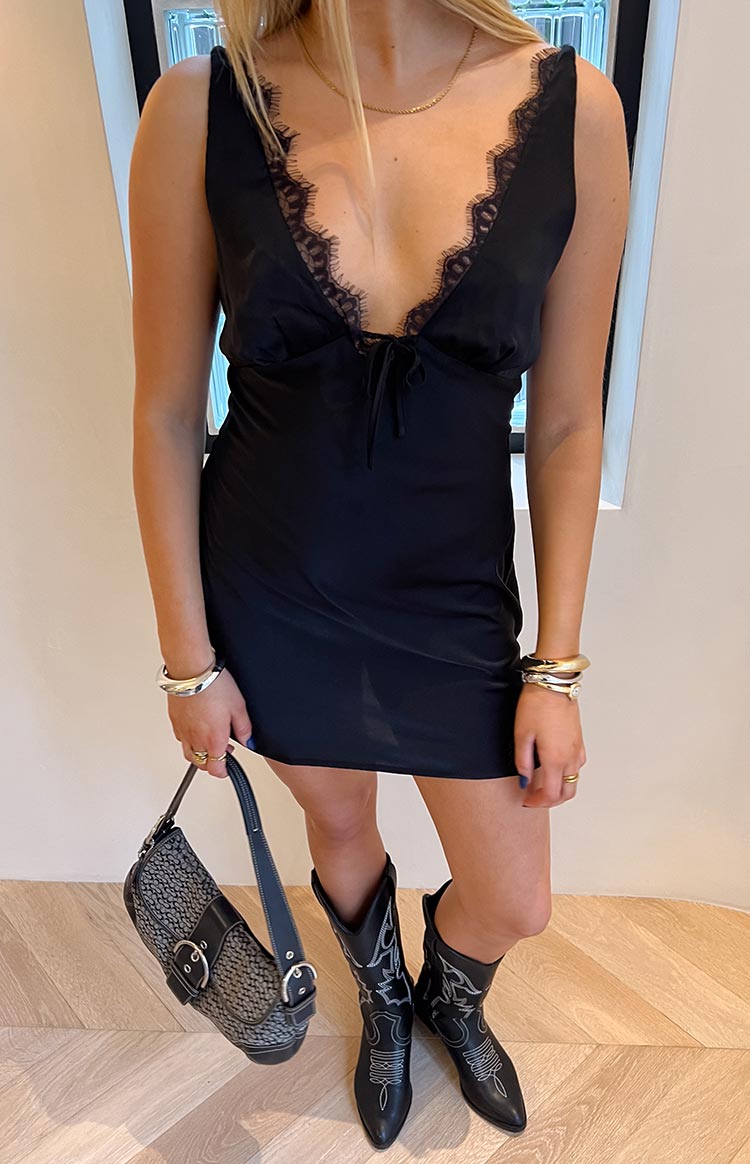 Black mini party dress with deep V-neckline, black lace trim, and tie-front bust detail