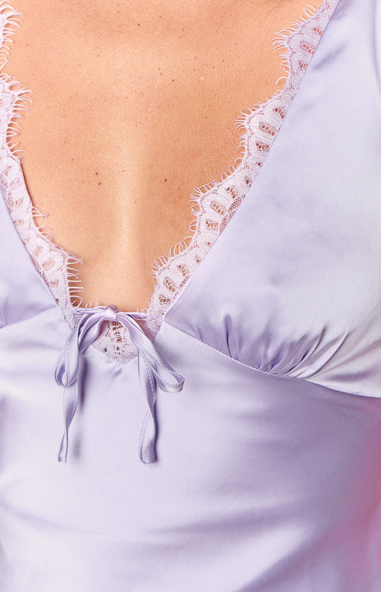 Close-up of the purple satin V-neck mini dress with delicate lace trim and a small tie detail at the bust